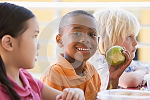 Kindergarten children eating lunch photo