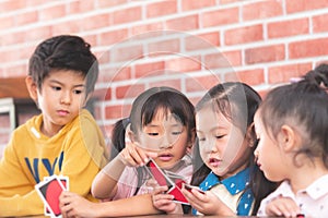 Kindergarten children playing counting card in class room