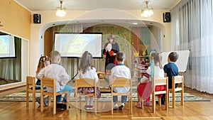 kindergarten education. teacher conducts a group lesson with children in a spacious bright room. woman and children are