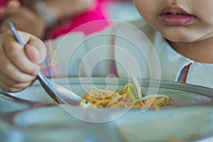 Kindergarten student is eating Pad Thai