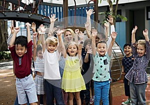 Kindergarten students with arms raised