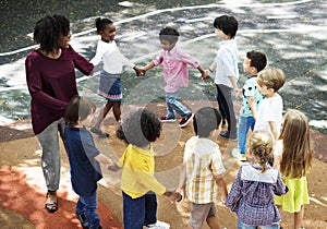 Kindergarten students standing holding hands in circle form
