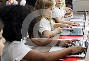 Kindergarten students using laptop in a class