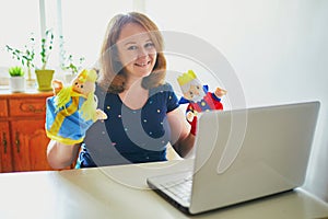 Kindergarten teacher in front of laptop having video conference chat with children