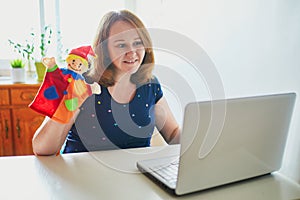Kindergarten teacher in front of laptop having video conference chat with children