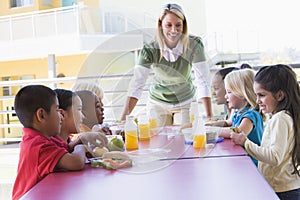 Kindergarten teacher supervising children photo