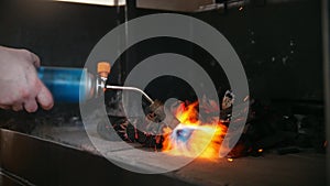 Kindling of charcoal in the barbecue oven using a gas burner