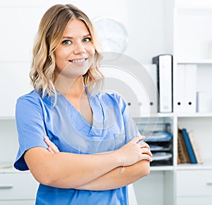 Kindly woman in doctor's uniform greets visitors at modern office