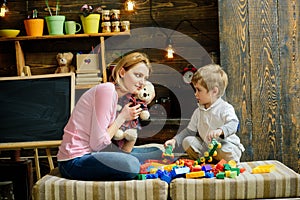 Kindness and education concept. Family play with teddy bear at home. Mom and child play with soft toy. Nursery with