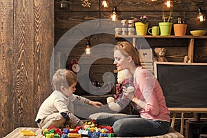 Kindness and education concept. Mother teaches son to be kind and friendly. Family play with teddy bear at home. Mom and