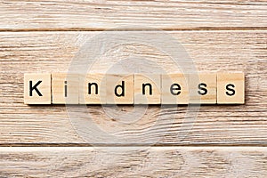 Kindness word written on wood block. kindness text on table, concept