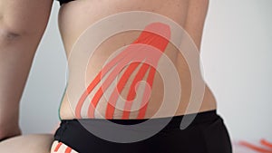 kinesio tape on women patient's lower back. Kinesiology, physical therapy, rehabilitation