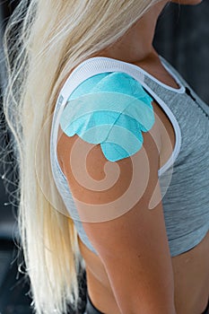 Kinesio taping, kinesiology. Girl with kinesio tape, muscle tape on the shoulder