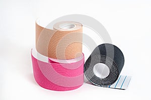 Kinesiological multi-colored tapes for fixing muscles during sports and after injuries on a white background