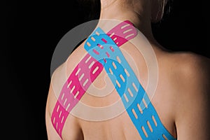 Kinesiological tape on the back of a young woman.