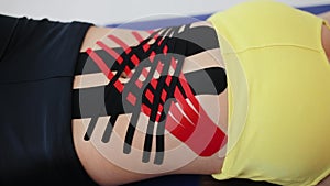 Kinesiology tape on girl belly. Sexy body with kinesio tape on the abdomen of young girl. Sport tratment.