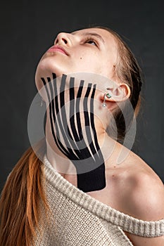 Kinesiology tape placed on the neck of a young caucasian teenager girl