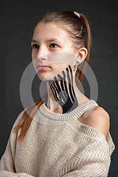 Kinesiology tape placed on the neck of a young caucasian teenager girl