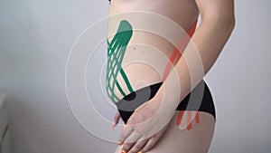 Kinesiology taping. kinesiology tape to patient belly.Anti-cellulite procedure for slim tummy. cellulite removal, sport