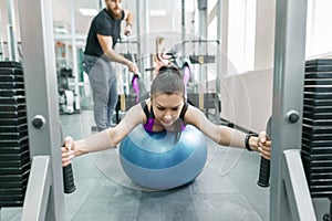 Kinesis technology, kinesitherapy, healthy lifestyle. Young woman doing rehabilitation exercises with personal instructor using