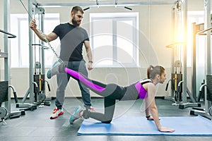 Kinesis technology, kinesitherapy, healthy lifestyle. Young woman doing rehabilitation exercises with personal instructor using