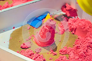 Kinetic Sand In A Heap For Indoor Game Or Children Creativity. Forms for the construction of the kinetic and pink sand scattered o