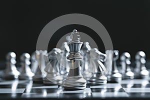 King of battle chess game stand on chessboard with black isolated background. Business leader concept