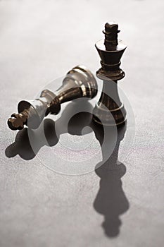 2 King Chess figures, one stands, one downs