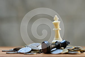 A King Chess is placed on a pile of coins.using as background business concept and Strategy concept with copy space for your text photo