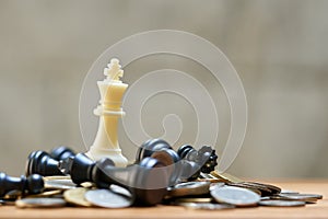 A King Chess is placed on a pile of coins.using as background business concept and Strategy concept with copy space for your text photo