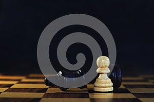 King encounters against powerful pawn in chess game, business competitive concept photo