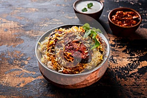 king fish biryani with raita served in a golden dish isolated on dark background side view food