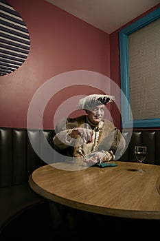 King Henry VIII counting money at table in bar photo