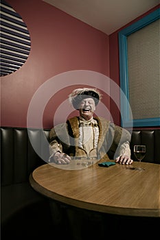 King Henry VIII counting money at table laughing photo