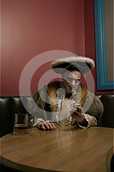 King Henry VIII using mobile phone at table