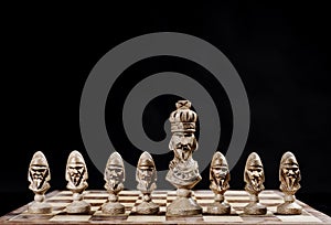 King with pawns on a chessboard on a black background photo