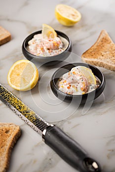 King prawn shrimps salad with orange salmon Keta caviar roe, herbs, lemon zest, cream and whole grain toast bread in bowl