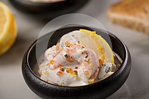 King prawn shrimps salad with orange salmon Keta caviar roe, herbs, lemon zest, cream and whole grain toast bread in bowl