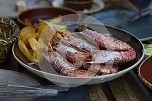 King prawns on a plate with potato chips aside served in a restaurant
