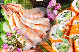 King prawns on plate with rolls and sushi decorated with sakura flowers