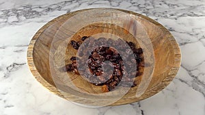 king raisins falling in to wooden plate. slow motion