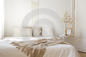 King size bed with white and beige pillows, real photo