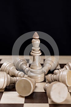 King surrounded by a lot of fallen white chess pawns
