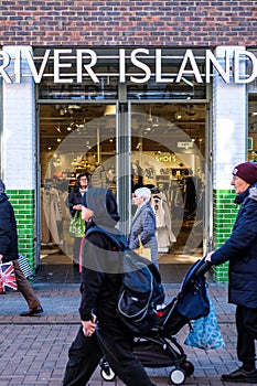 People Walking Past A Branch Of A River Island Fashion Shop