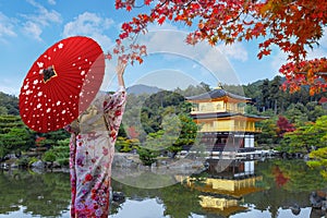 Japanese Woman in Traditional Kimono Dress at Kinkakuj temple beautiful vivid autumn colorful foliage in Kyoto, Japan photo