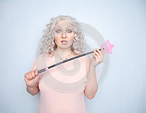 Kinky pretty woman with pink star riding crop. cute blonde woman holds bdsm whip on white solid studio background.