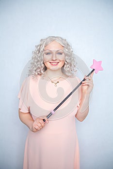 Kinky pretty woman with pink star riding crop. cute blonde woman holds bdsm whip on white solid studio background.