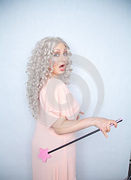 Kinky pretty woman with pink star riding crop. cute blonde woman holds bdsm whip on white solid studio background.