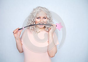 Kinky pretty woman with pink star riding crop. cute blonde woman holds bdsm whip on white solid studio background.