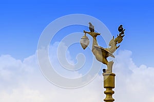 Kinnaree decorated Lamp,Golden swan statue with birds and blue sky.